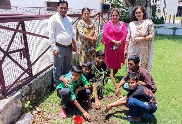 पौधारोपण करते अधिकारी व बच्चे